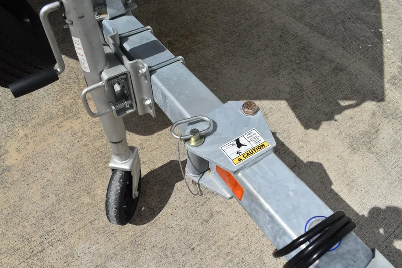 Slide: The Image of Trailer hitch of 2025 Lowe RX1860 Tunnel Jet with caution label on concrete surface. - 26