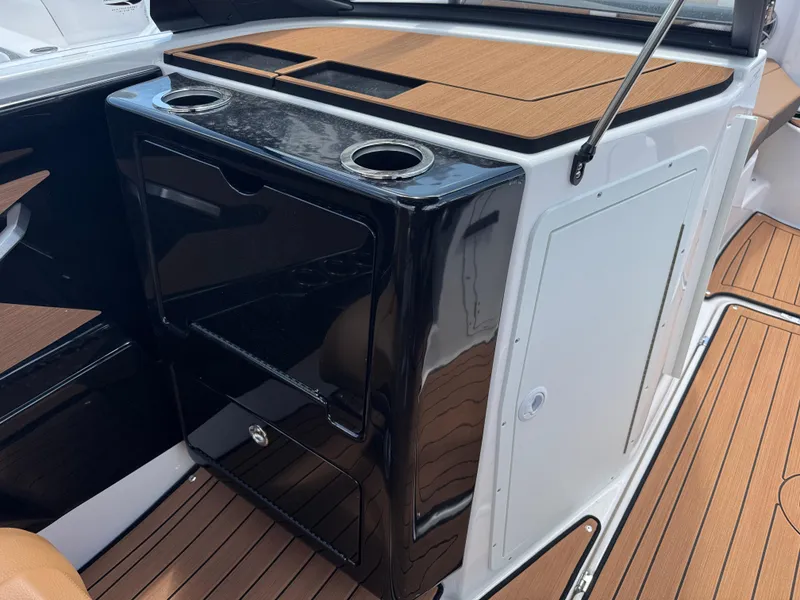 Slide: The Image of 2025 Yamaha Boats 222S interior with sleek black console and wood accents. - 10