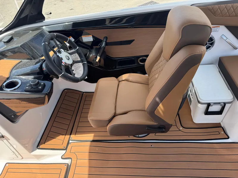 Slide: The Image of 2025 Yamaha Boats 222S cockpit with tan seating and modern steering controls. - 16