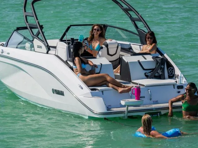 Slide: The Image of 2025 Yamaha Boats 222S with people relaxing on and around it in clear water. - 30