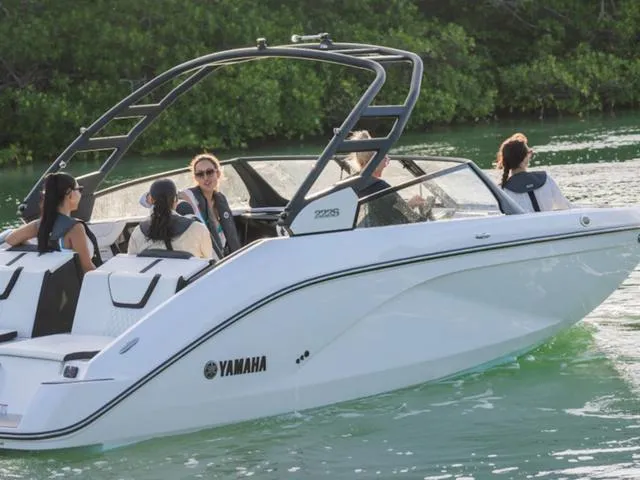 Slide: The Image of 2025 Yamaha Boats 222S cruising on a serene waterway with passengers enjoying the ride. - 31