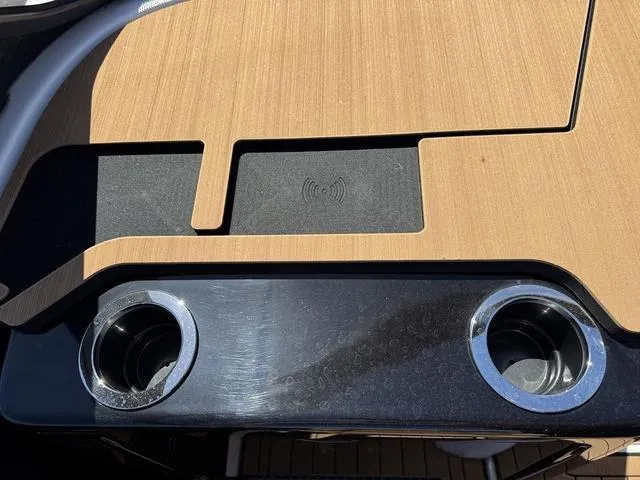 Slide: The Image of 2025 Yamaha Boats 222SD interior with cup holders and wireless charging pad. - 11