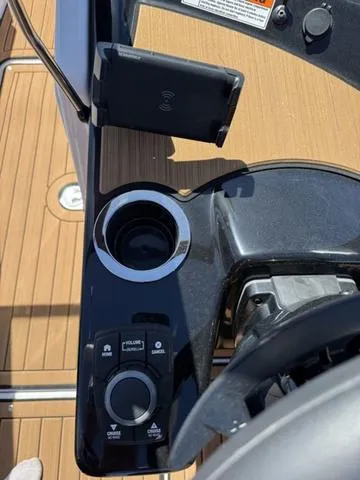 Slide: The Image of Control panel of 2025 Yamaha Boats 222SD, featuring cup holder and wireless charging dock. - 18