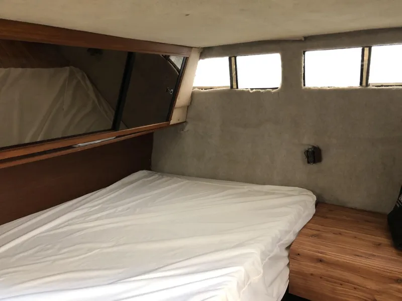 Slide: The Image of 1987 Sea Ray 360 Aft Cabin interior with bed, wood accents, and windows. - 14