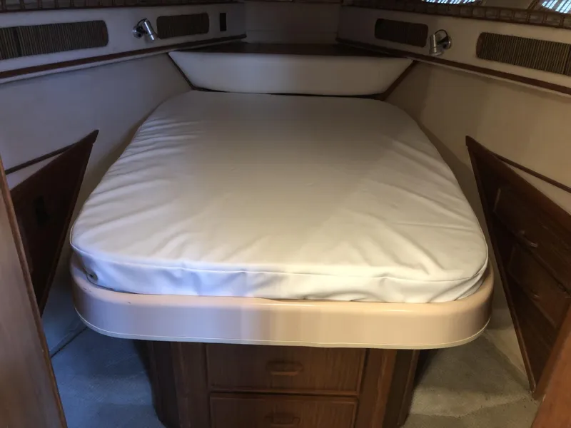 Slide: The Image of 1987 Sea Ray 360 Aft Cabin interior with a cozy bed and wooden cabinetry. - 4