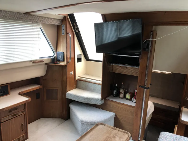 Slide: The Image of Interior of 1987 Sea Ray 360 Aft Cabin with TV, stairs, and wooden cabinetry. - 5