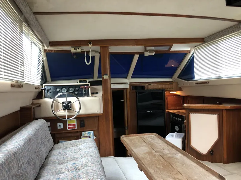 Slide: The Image of Interior of 1987 Sea Ray 360 Aft Cabin with helm, seating, and wooden accents. - 7