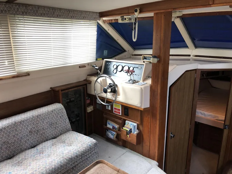 Slide: The Image of 1987 Sea Ray 360 Aft Cabin interior with helm, sofa, and cabin entrance. - 8