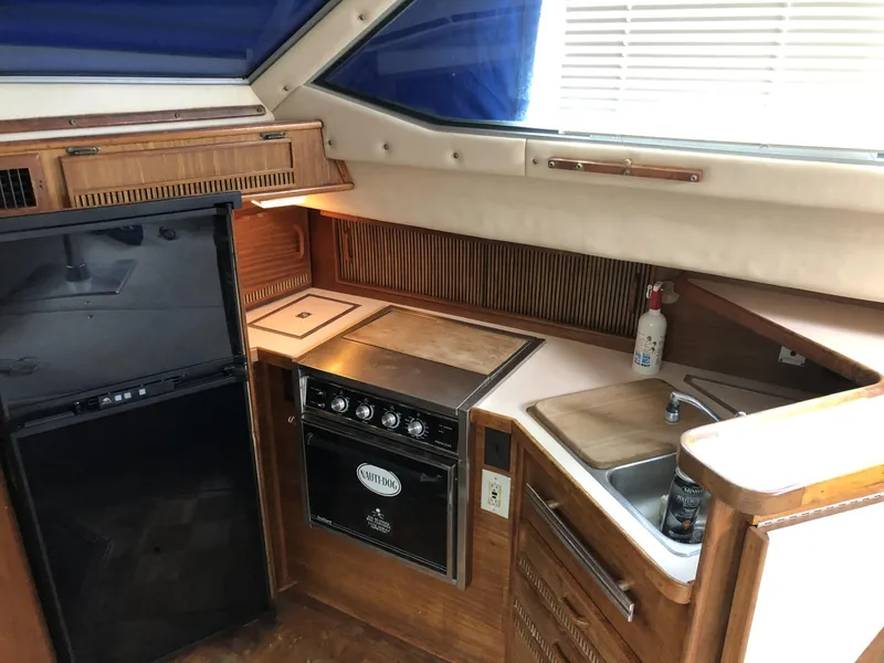 Slide: The Image of 1987 Sea Ray 360 Aft Cabin kitchen with stove, sink, and refrigerator. - 9