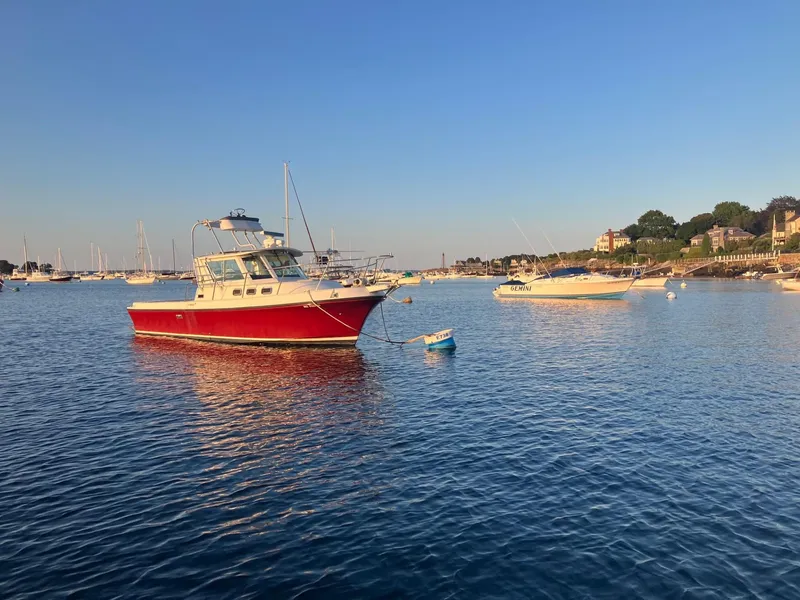 Slide: The Image of Red 1997 Albin 28 Tournament boat anchored in a serene harbor at sunset. - 2