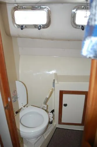 Slide: The Image of 1997 Albin 28 Tournament boat bathroom with toilet, cabinet, and portholes. - 9