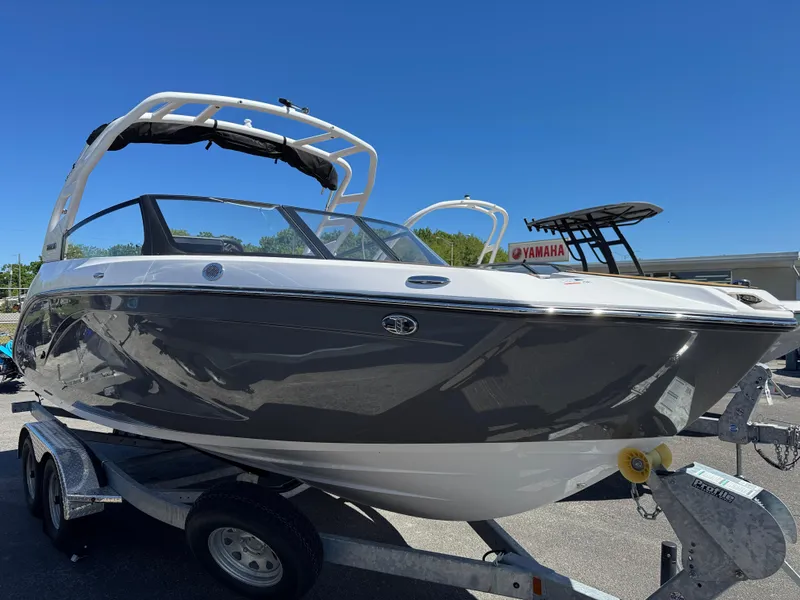 The Image of 2025 Yamaha Boats 222SD on trailer, sleek design, gray and white exterior, sunny day. - 0