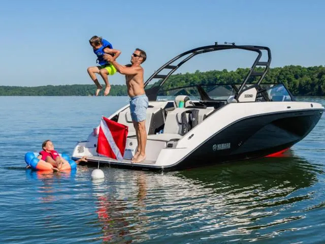 Slide: The Image of 2025 Yamaha Boats 222SD on lake, family enjoying water activities, clear blue sky. - 36