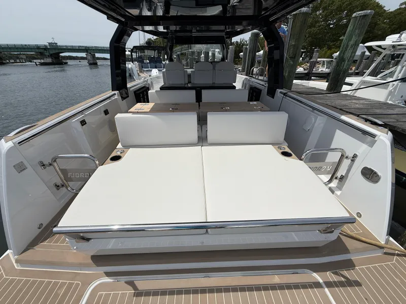 Slide: The Image of 2025 Fjord 39 XP yacht with spacious seating and sleek design at a marina. - 15