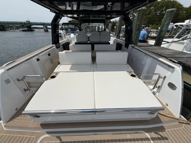 Slide: The Image of 2025 Fjord 39 XP yacht with spacious sunbathing area at the stern, docked by the water. - 16