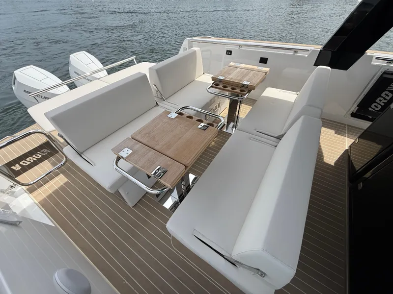 Slide: The Image of Luxurious seating area on 2025 Fjord 39 XP yacht with wooden tables and water view. - 34
