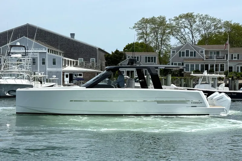 Slide: The Image of 2025 Fjord 39 XP yacht cruising near coastal buildings and marina. - 4