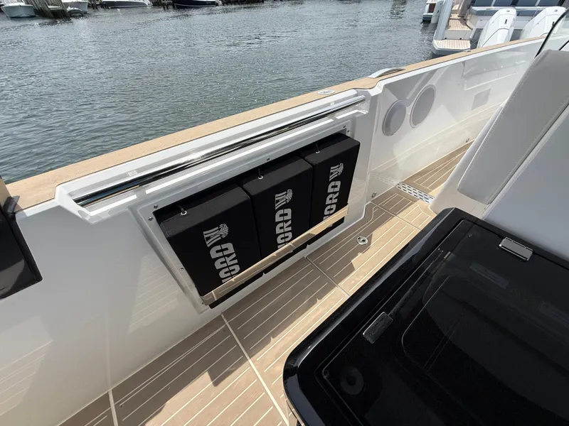 Slide: The Image of 2025 Fjord 39 XP yacht deck with storage compartments, docked by the water. - 44