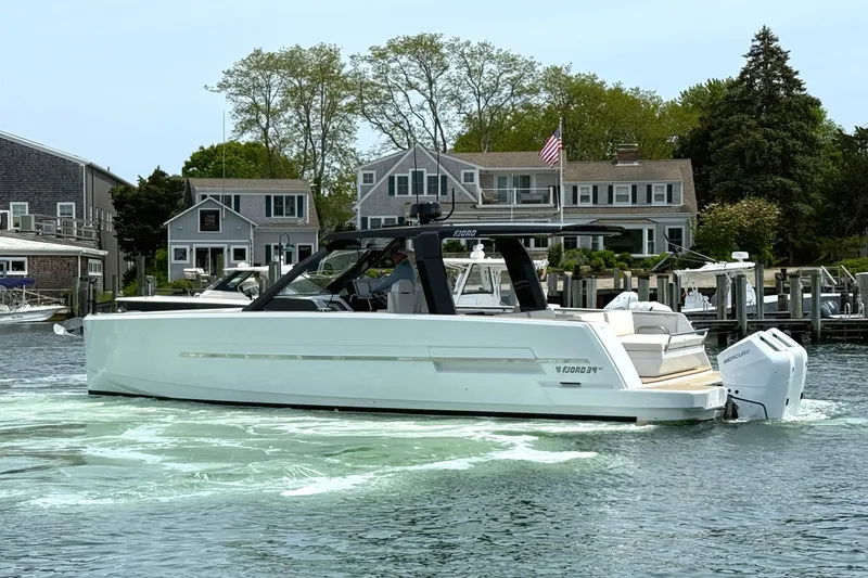 Slide: The Image of 2025 Fjord 39 XP yacht cruising near waterfront homes. - 5