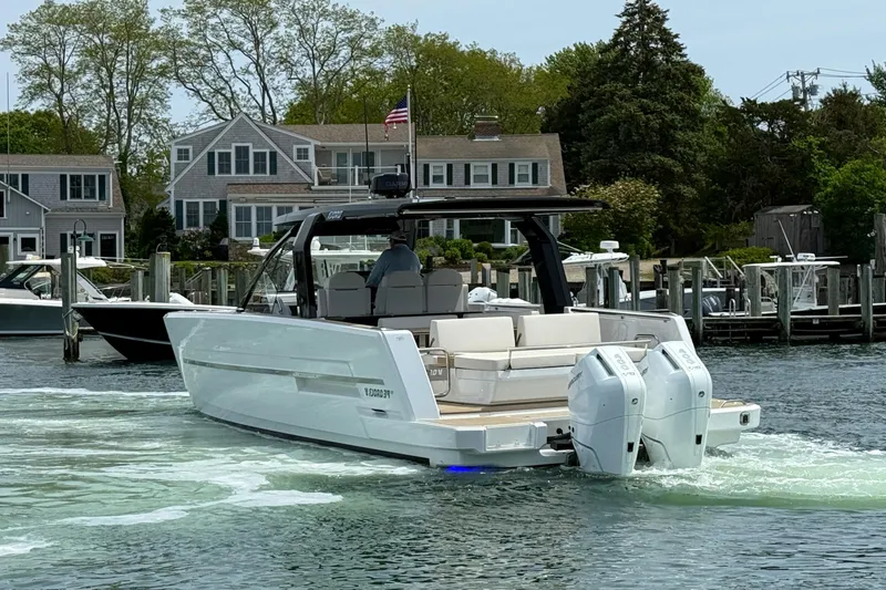 Slide: The Image of 2025 Fjord 39 XP boat cruising near waterfront homes, showcasing sleek design and powerful engines. - 6