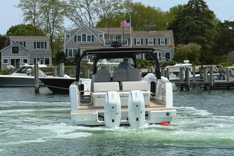 Slide: The Image of 2025 Fjord 39 XP boat with dual engines, docked near waterfront homes. - 7