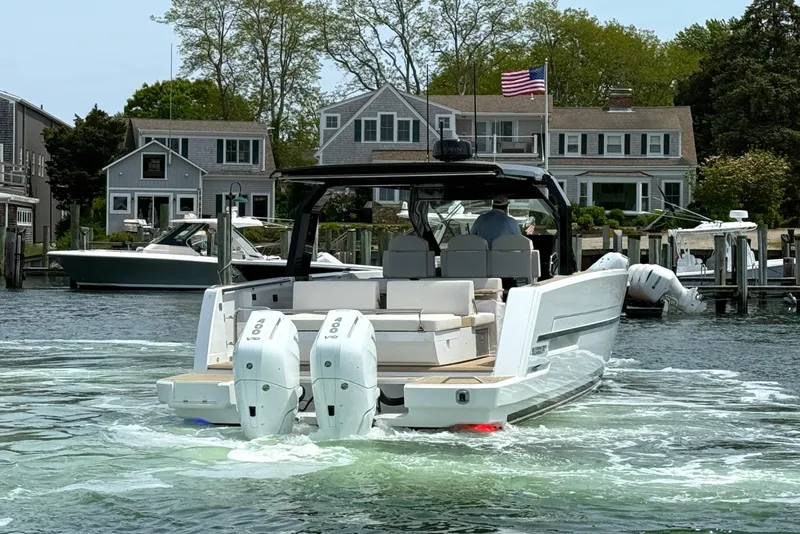 Slide: The Image of 2025 Fjord 39 XP boat with dual engines, docked near waterfront homes. - 8