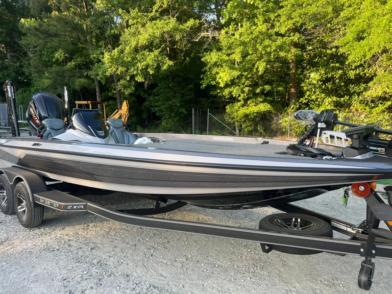 The Image of 2025 Skeeter ZXR 21 boat on trailer, parked outdoors near trees. - 0