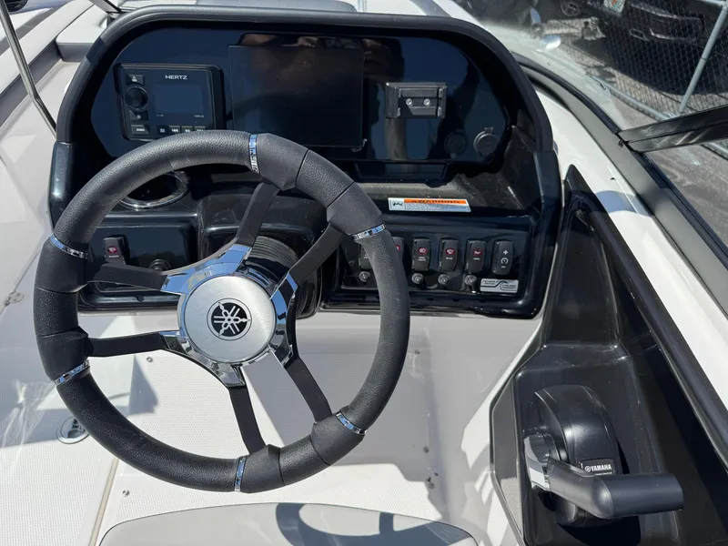 Slide: The Image of Steering wheel and dashboard of 2025 Yamaha Boats 195S, featuring modern controls and displays. - 18