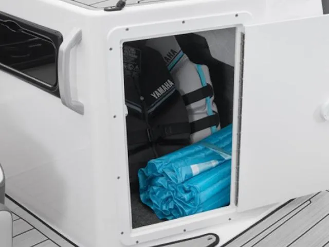 Slide: The Image of Storage compartment on 2025 Yamaha Boats 195S, featuring life jackets and blue gear. - 29