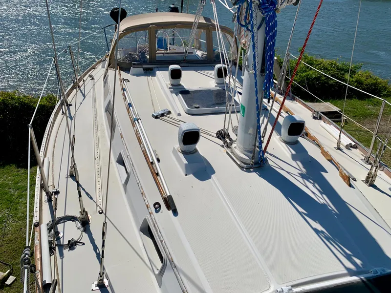 Slide: The Image of 1986 Sabre 36 sailboat deck with mast and rigging, docked by the water. - 11
