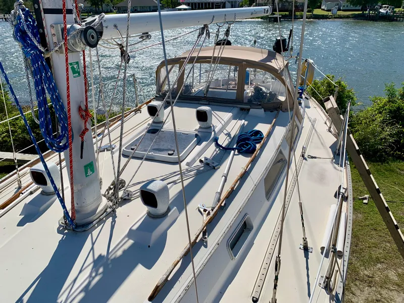 Slide: The Image of 1986 Sabre 36 sailboat deck with rigging, docked by a scenic waterfront. - 14