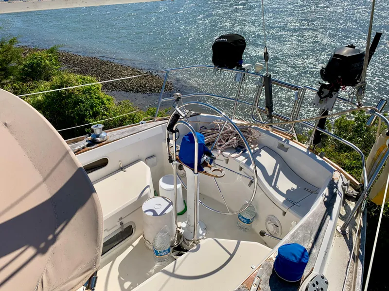 Slide: The Image of 1986 Sabre 36 sailboat cockpit with ocean view, featuring steering wheel and equipment. - 16