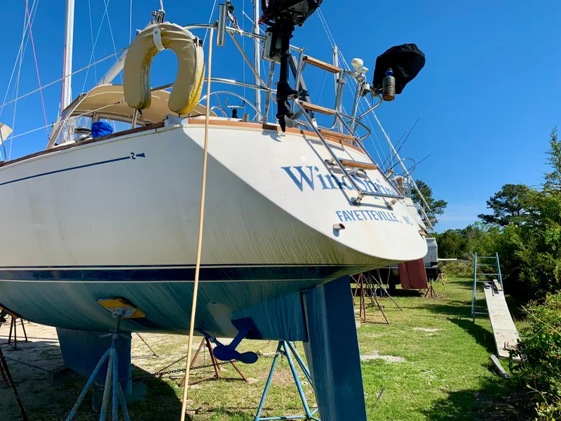 Slide: The Image of 1986 Sabre 36 sailboat on stands, blue sky background, grassy area. - 2