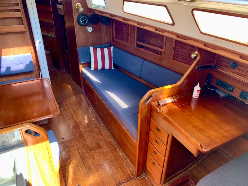 Slide: The Image of Interior of 1986 Sabre 36 sailboat with wooden furnishings and blue cushions. - 23