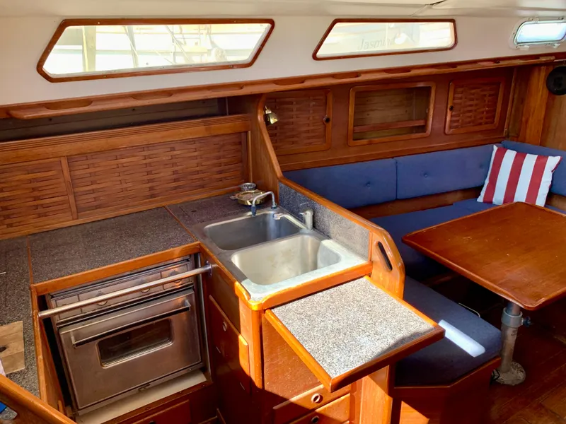 Slide: The Image of 1986 Sabre 36 yacht interior with kitchen, sink, and dining area. - 28