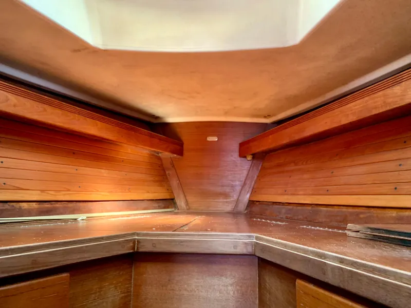 Slide: The Image of Interior of a 1986 Sabre 36 sailboat with wooden paneling and storage shelves. - 31