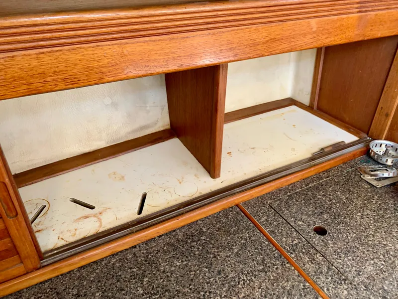 Slide: The Image of Wooden interior shelving of a 1986 Sabre 36 boat, featuring a granite-like countertop. - 38