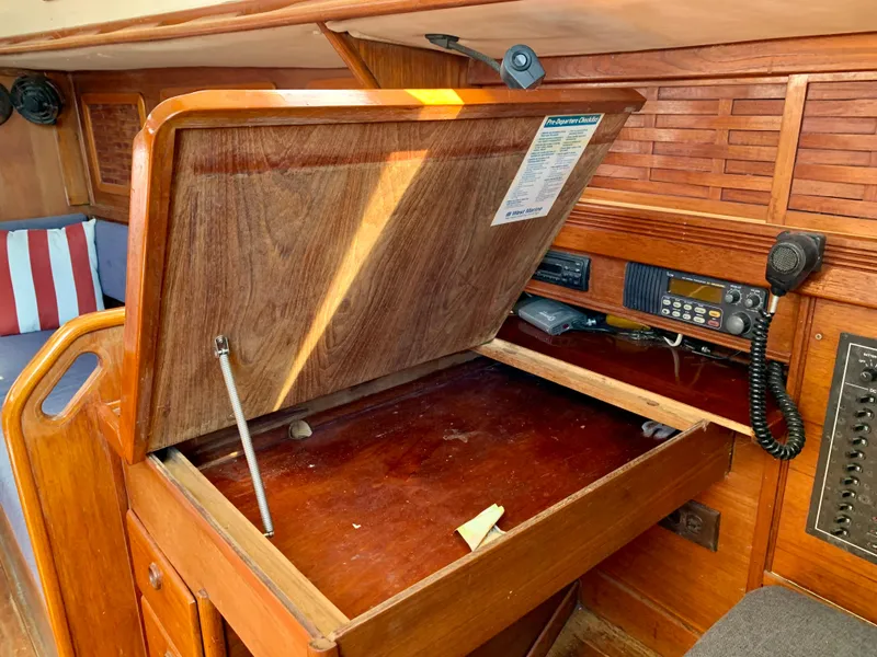 Slide: The Image of 1986 Sabre 36 sailboat interior with open wooden navigation desk and communication equipment. - 39