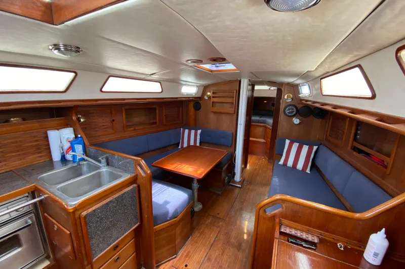 Slide: The Image of Interior of 1986 Sabre 36 sailboat with wooden finishes and cozy seating area. - 4