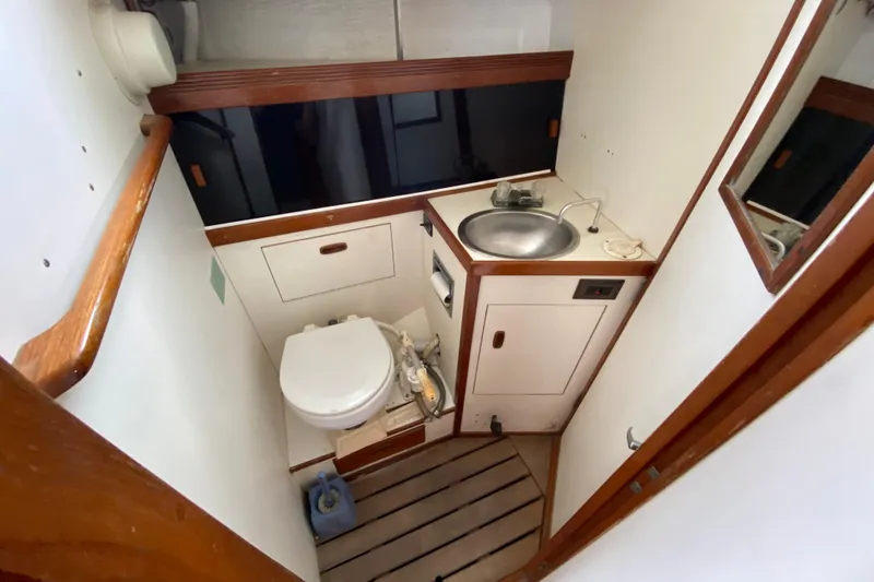 Slide: The Image of 1986 Sabre 36 yacht bathroom with sink, toilet, and wooden accents. - 9