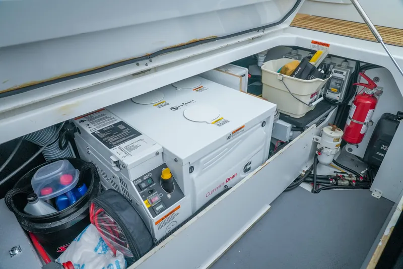 Slide: The Image of Engine compartment of a 2017 Jeanneau NC11 boat, featuring a generator and safety equipment. - 12