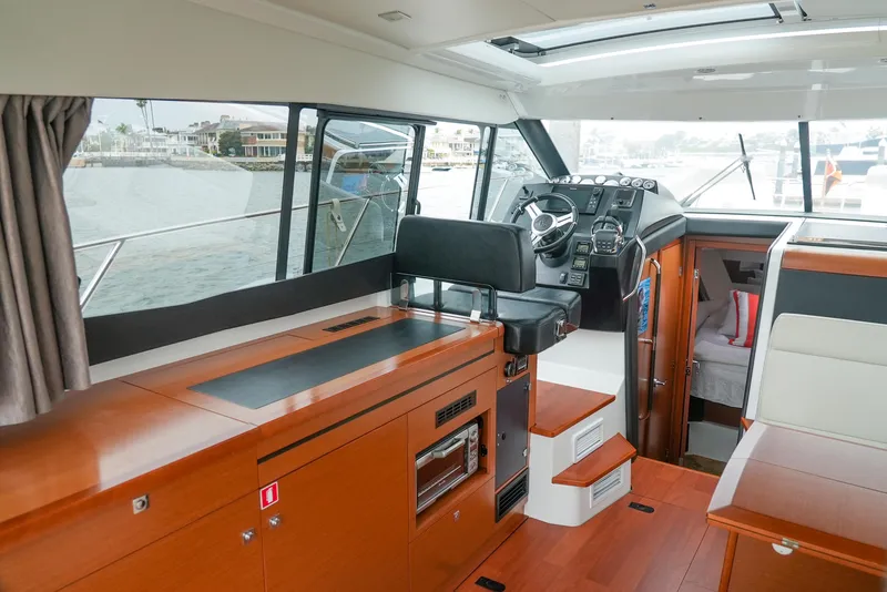 Slide: The Image of Interior of 2017 Jeanneau NC11 boat with modern helm and wooden finishes. - 16