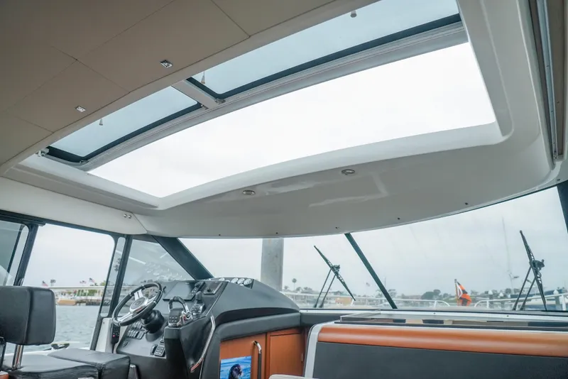 Slide: The Image of Interior view of 2017 Jeanneau NC11 boat with panoramic sunroof and modern helm. - 19