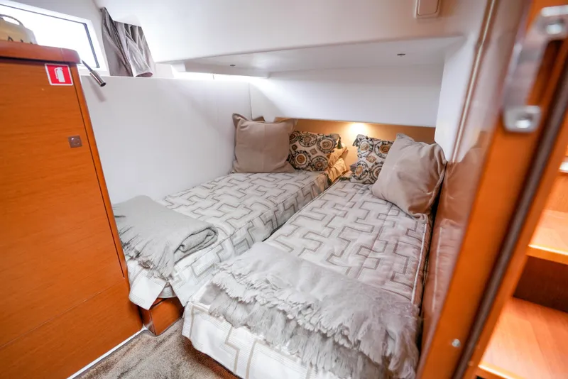 Slide: The Image of 2017 Jeanneau NC11 cabin with twin beds, cozy decor, and soft lighting. - 22