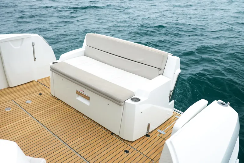 Slide: The Image of 2017 Jeanneau NC11 boat with cushioned seating on teak deck, overlooking the ocean. - 6