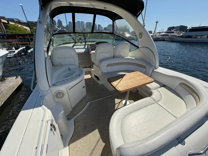 Slide: The Image of 2008 Sea Ray 340 Sundancer boat interior with seating and table, docked in a marina. - 11