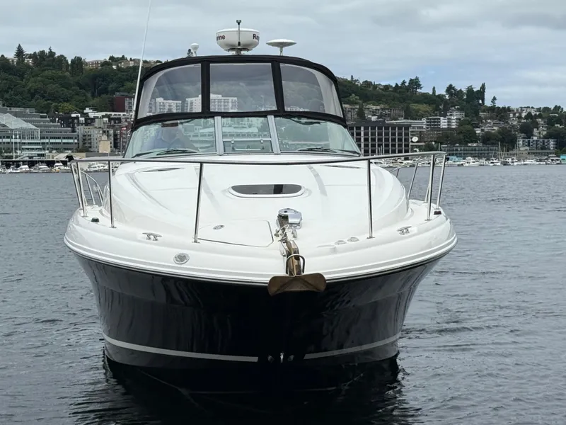 Slide: The Image of 2008 Sea Ray 340 Sundancer yacht on calm water, cityscape in background. - 2
