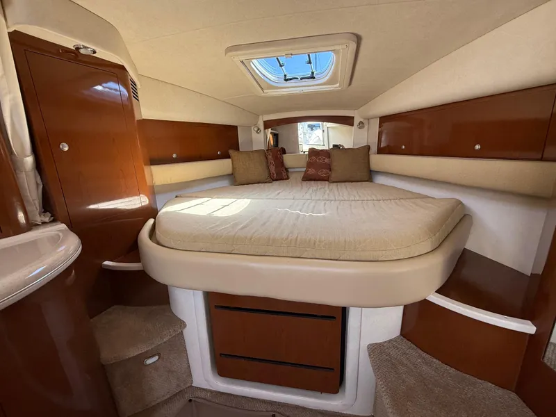 Slide: The Image of 2008 Sea Ray 340 Sundancer cabin with bed, wooden cabinets, and skylight. - 21
