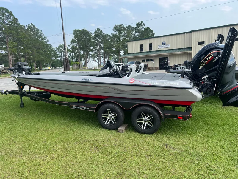 The Image of 2025 Skeeter ZXR 20 boat on trailer, parked on grass near a building. - 0