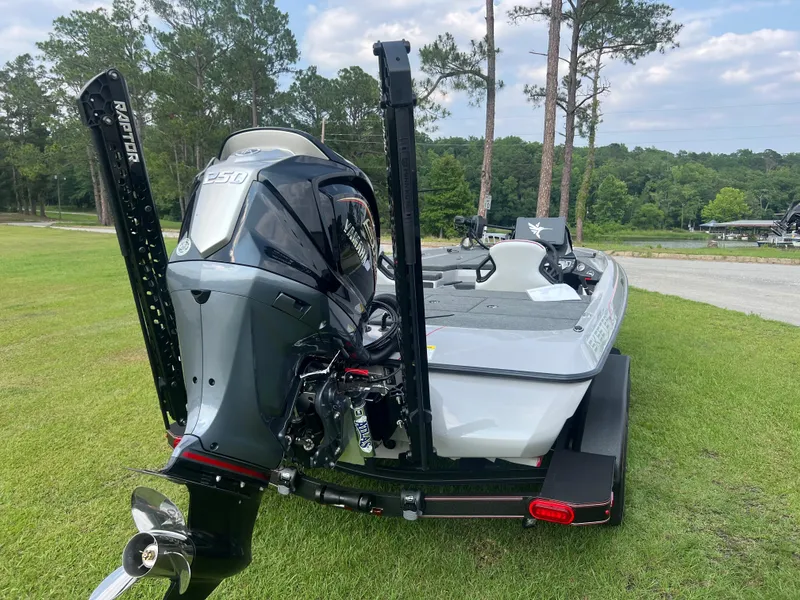 Slide: The Image of 2025 Skeeter ZXR 20 boat on grass, rear view with motor and trees in background. - 4